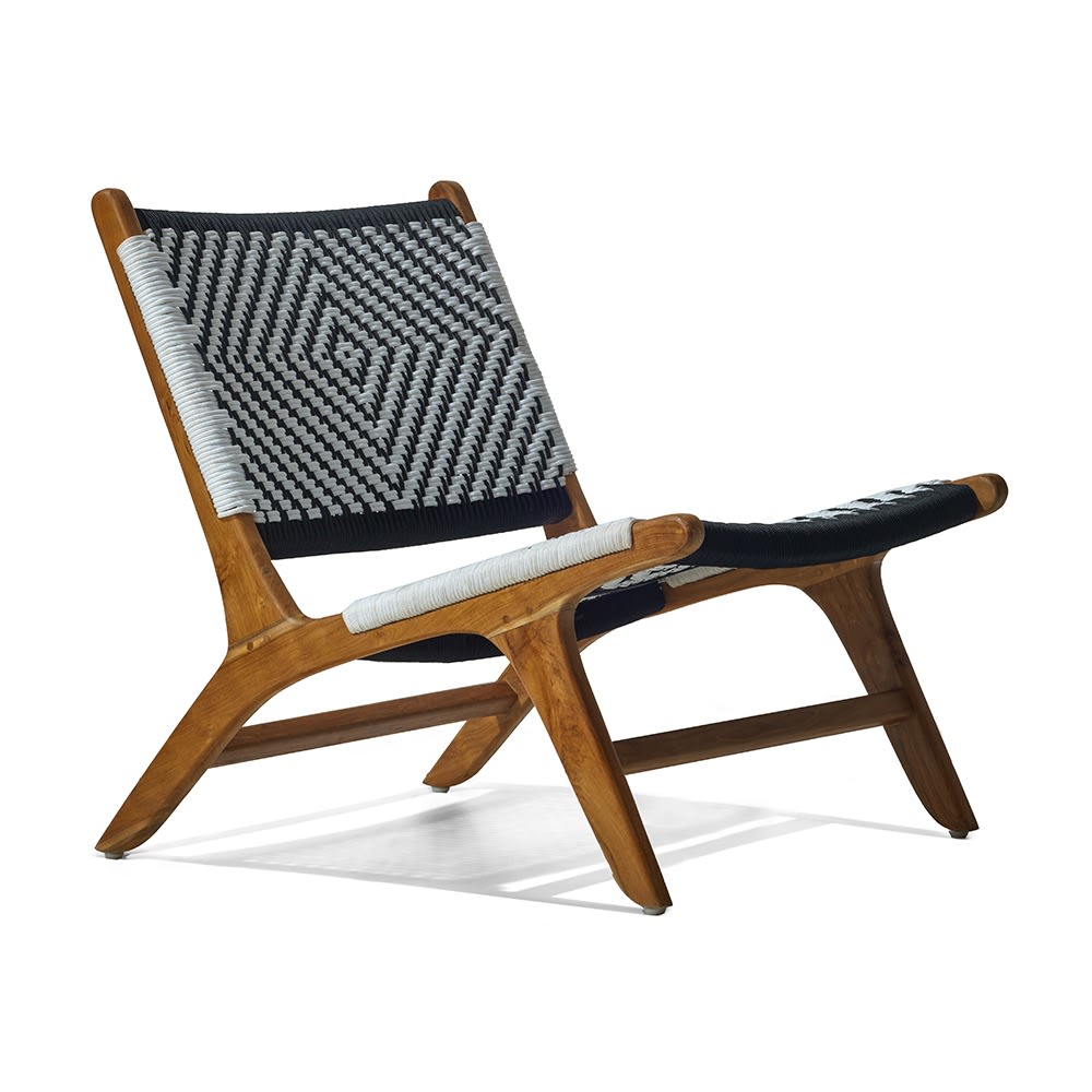 Silla de madera con estructura inclinada y asiento y respaldo tejidos a mano en patrón geométrico en blanco y negro. El diseño combina estilo moderno con artesanía tradicional.