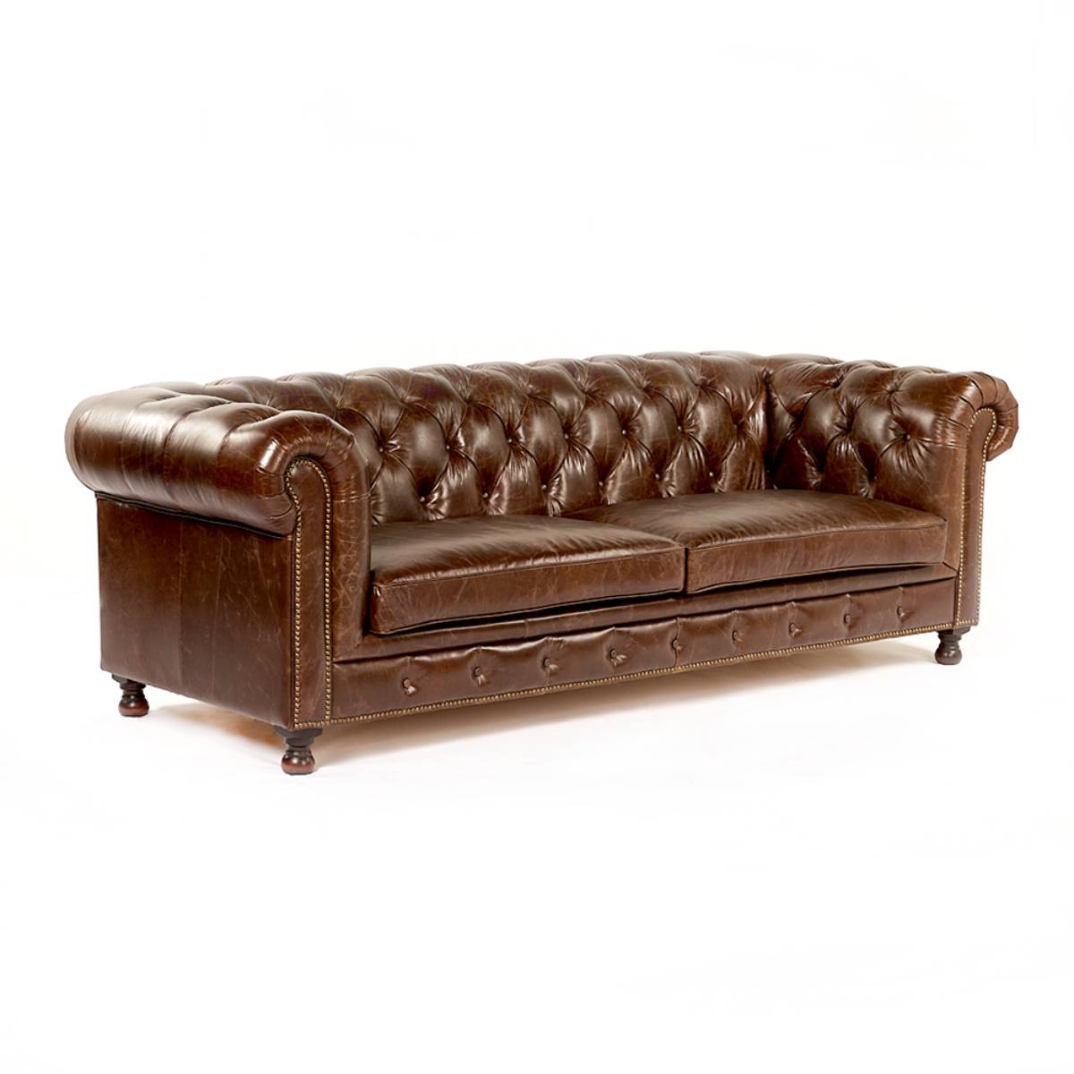 Sofá estilo Chesterfield de cuero marrón oscuro con respaldo y apoyabrazos capitoné. Tiene patas cortas de madera y detalles de tachuelas metálicas a lo largo de los bordes.