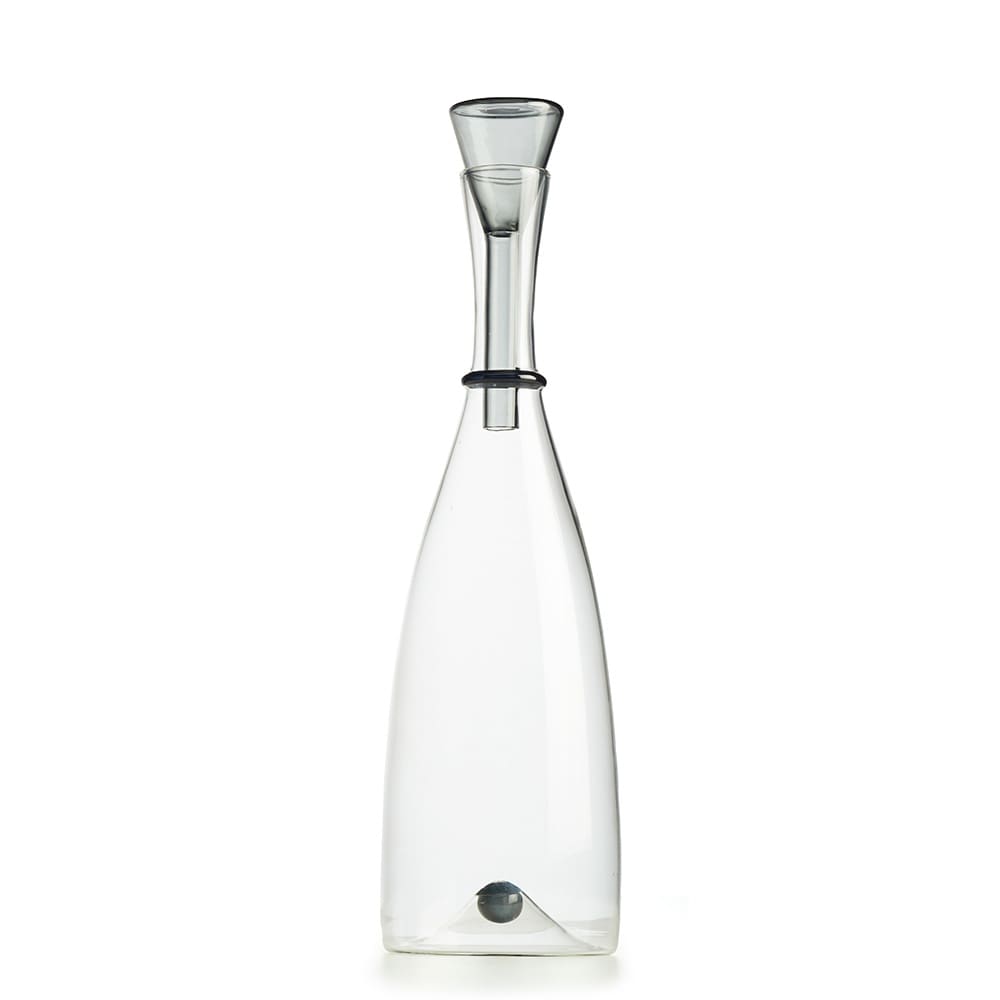 Botella de vidrio transparente con un diseño estilizado y moderno, con un tapón cónico en la parte superior y una esfera metálica en la base interior.