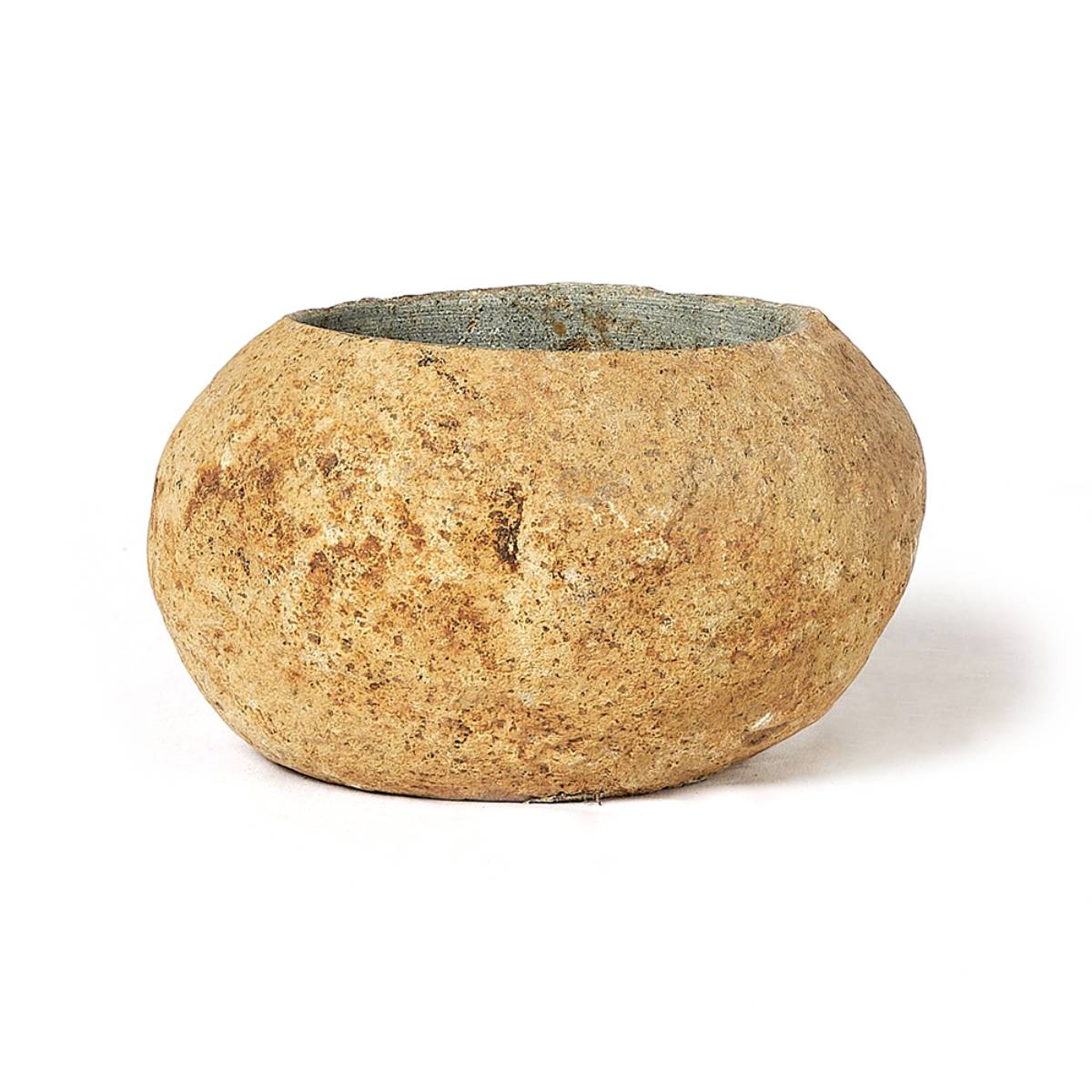 Recipiente rústico de piedra tallada, de forma redondeada con una abertura superior ancha y un acabado texturizado. El interior muestra un leve tono verdoso contrastando con el exterior marrón terroso.