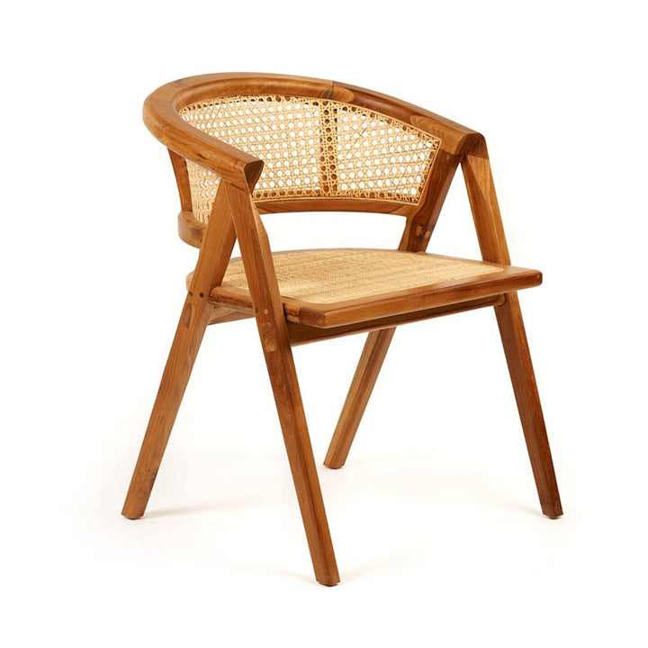 La imagen muestra una silla de madera clara con diseño de respaldo y asiento de mimbre tejido. Tiene una estructura angular moderna con un respaldo semicircular que conecta los apoyabrazos.