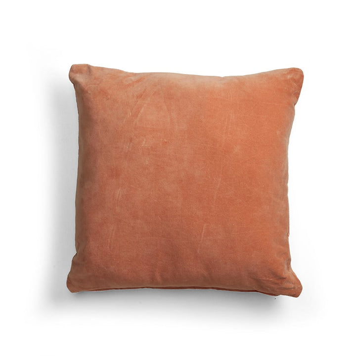 Almohadón cuadrado de terciopelo en color terracota, con textura suave y apariencia mullida. No presenta inscripciones ni detalles visibles.