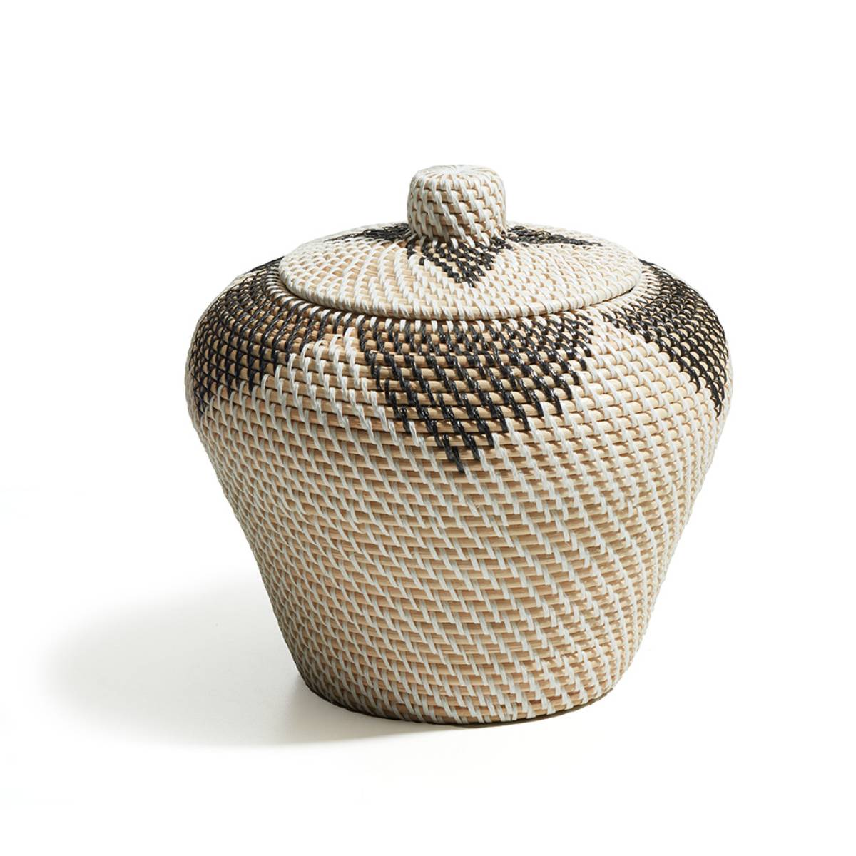 Recipiente tejido con tapa, de forma redondeada y patrón geométrico con colores crema, beige y marrón oscuro. No presenta detalles escritos visibles.