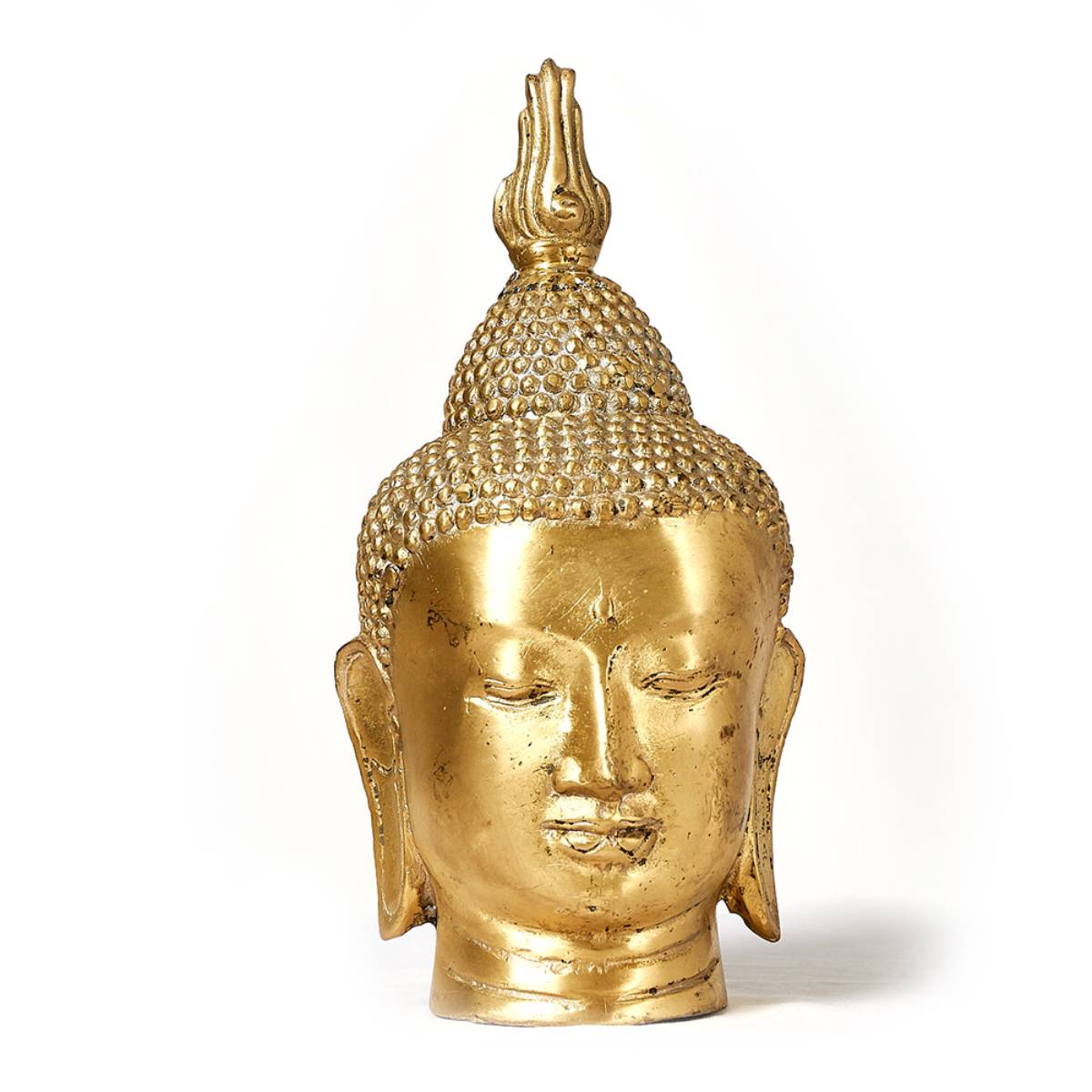 Cabeza dorada de Buda con expresión serena y ojos semicerrados; presenta detalles en relieve en el cabello y un acabado metálico brillante. No hay texto ni inscripciones visibles en el objeto.