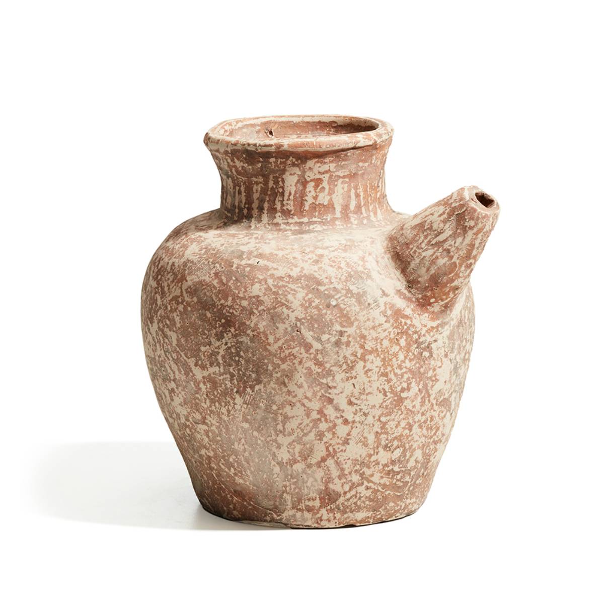 Jarra de barro de cuerpo ancho con una superficie desgastada de aspecto rústico y una boquilla lateral. El acabado muestra marcas de uso y pátina que le dan un carácter antiguo.