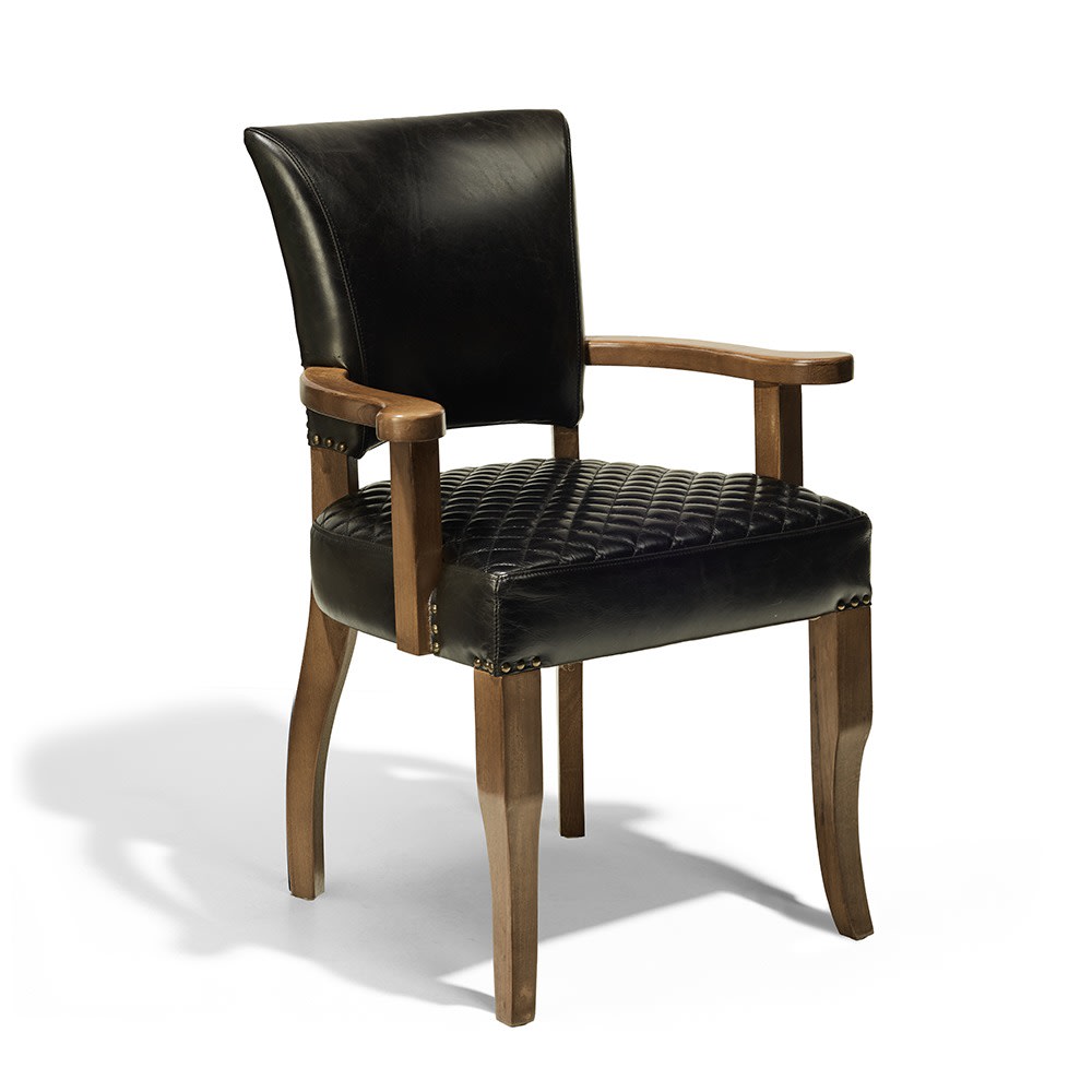 Silla de respaldo alto con estructura de madera clara y asiento acolchado de cuero marrón con patrón de rombos pespunteados. También tiene apoyabrazos y tachuelas decorativas en la base del asiento.