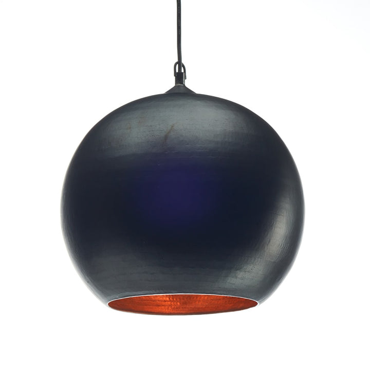 Lámpara colgante de forma esférica con acabado exterior en azul oscuro metálico y el interior en color cobre brillante; cuelga de un cable negro delgado.