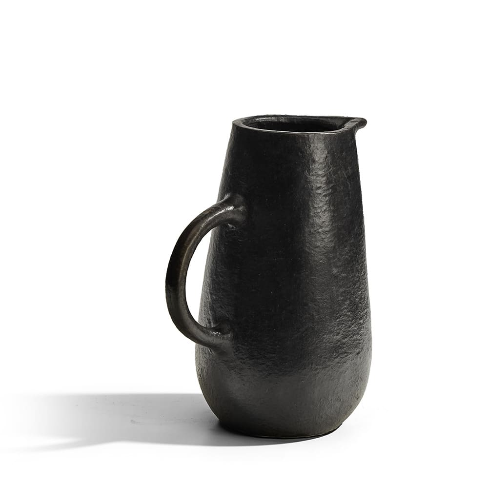 Jarra de cerámica negra con superficie texturizada y acabado mate, de diseño minimalista y asa lateral curva.