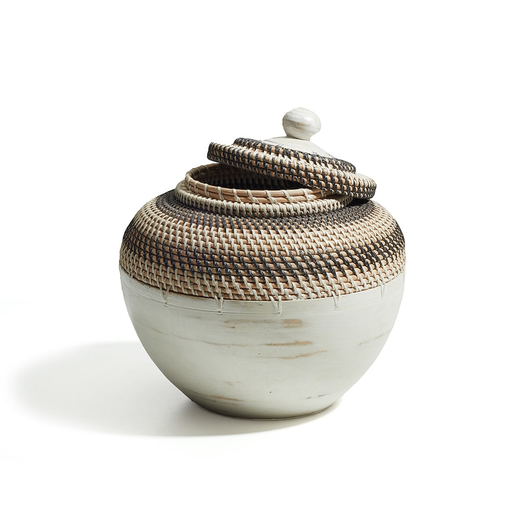 Recipiente redondo con tapa, hecho de cerámica en la base y tejido de fibra natural en la parte superior; el tejido tiene un patrón en espiral en tonos marrones, beige y negro.