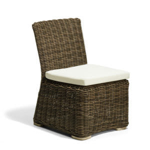 Silla de mimbre sintético de color marrón con un cojín beige claro en el asiento. El diseño es sencillo y sin apoyabrazos, ideal para exteriores o interiores rústicos.