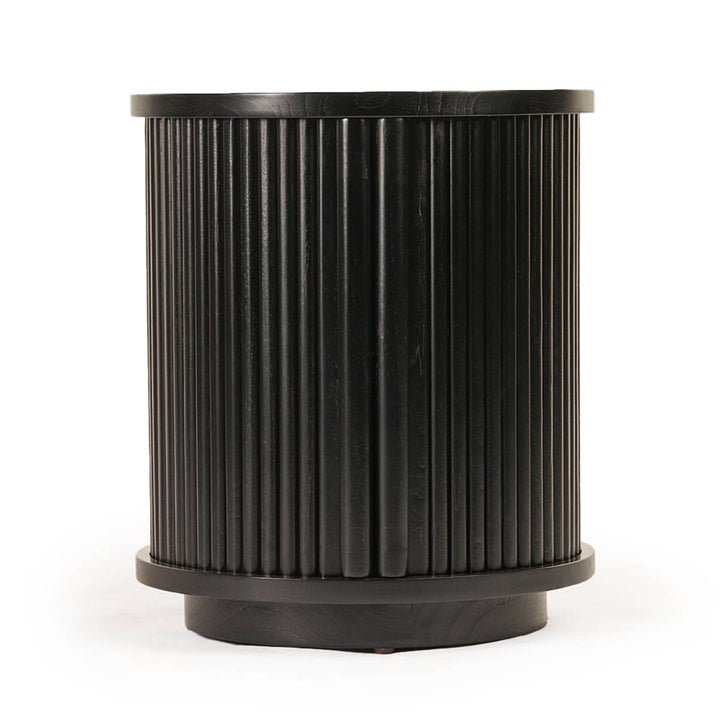Cilindro de madera negra con diseño acanalado vertical en toda su superficie, posiblemente utilizado como mesa auxiliar o taburete decorativo. Su acabado es uniforme y moderno.