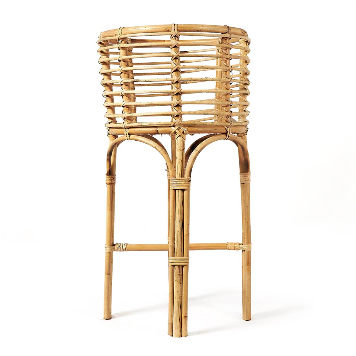 Soporte alto de mimbre tejido con estructura firme, utilizado comúnmente como porta macetas o elemento decorativo. Presenta un diseño natural con un patrón circular entrelazado en la parte superior.